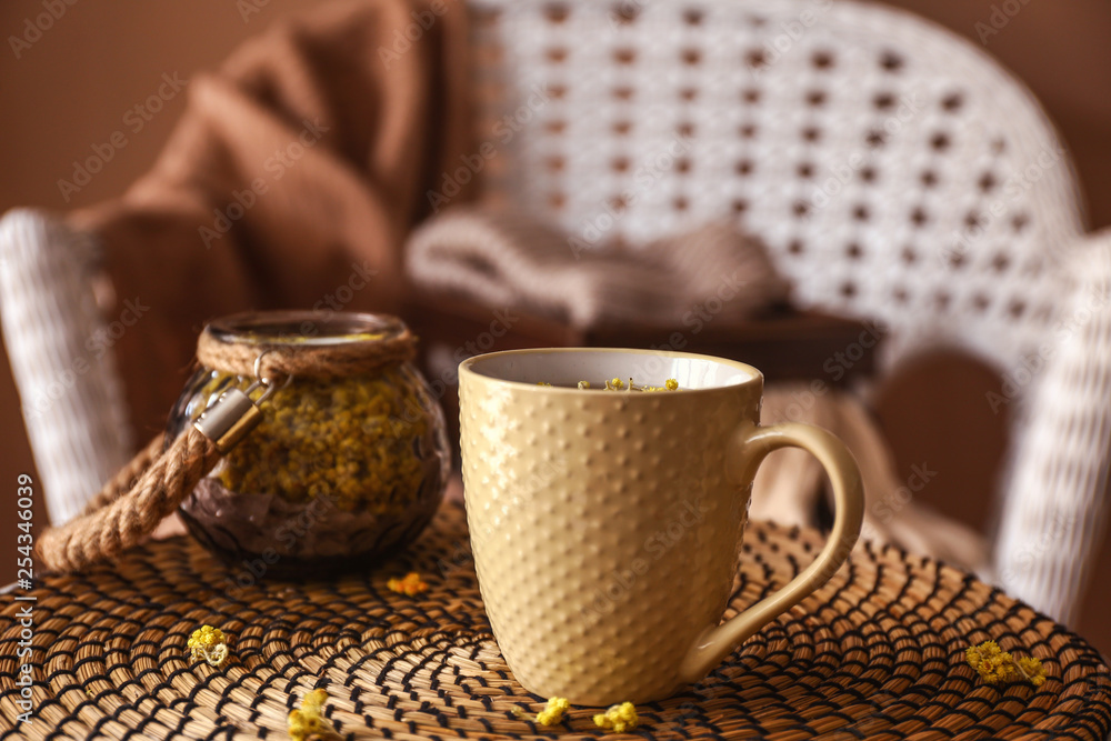 一杯热茶和柳条垫上的蜡烛架