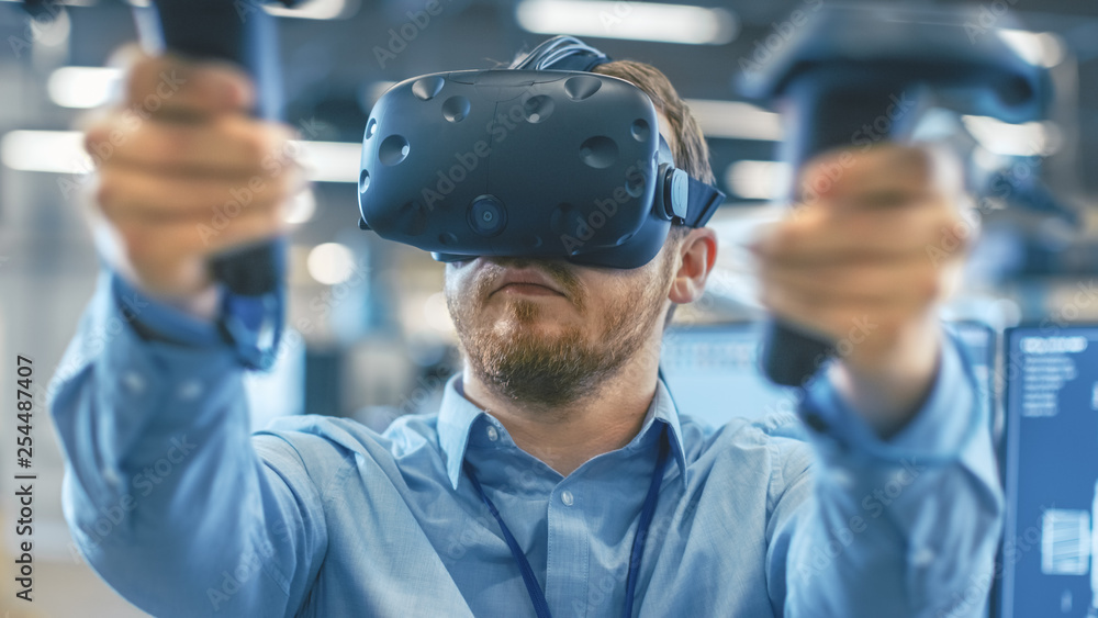 Portrait Shot of the Industrial Engineer Wearing Virtual Reality Headset and Using Controllers, read