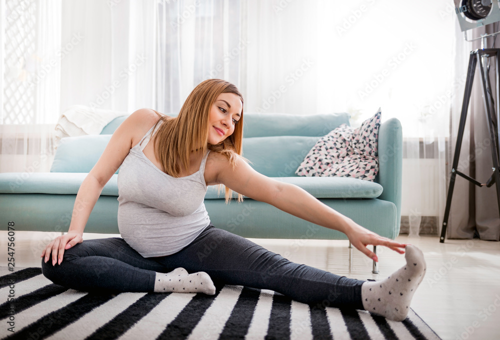 漂亮孕妇在家客厅锻炼，孕期健康