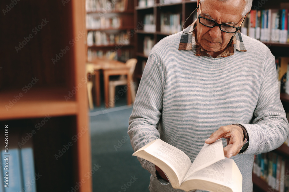 一位老年人在图书馆看书的肖像
