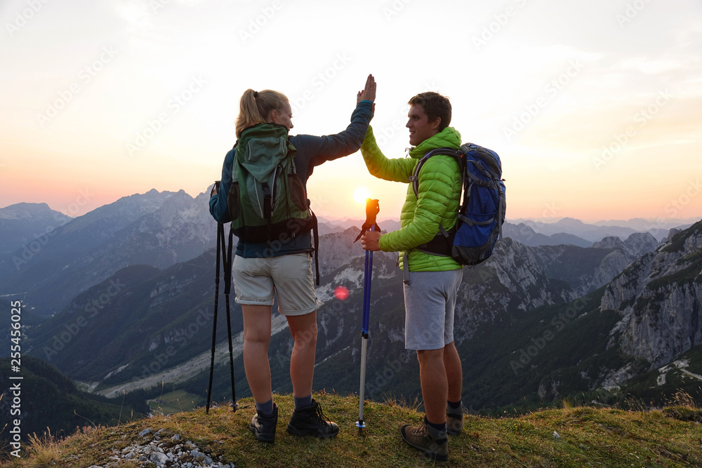 SUN FLARE: Cheerful hikers high five after successfully climbing a mountain.