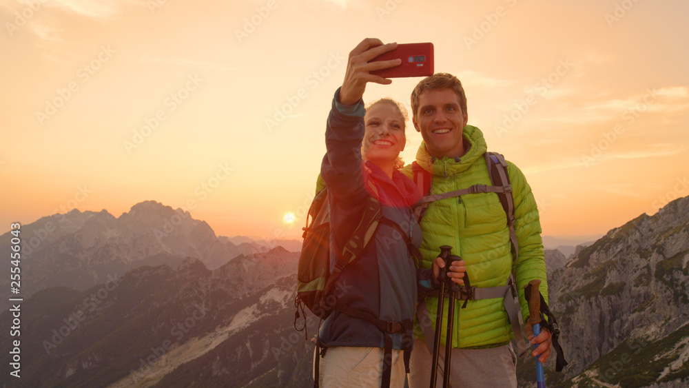 太阳耀斑：新婚夫妇在日出时到达山顶后自拍。
