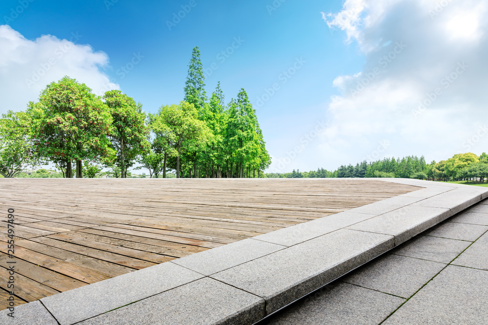城市公园里的空木板、方形平台和绿色树林