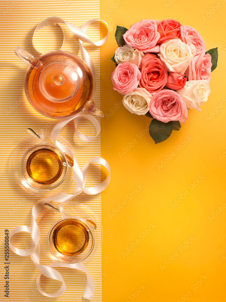黄色背景的英式玻璃茶具和玫瑰，带有复制空间。