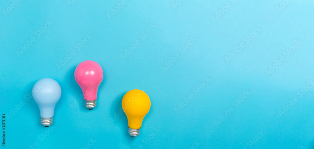 Colored light bulbs on a blue paper background