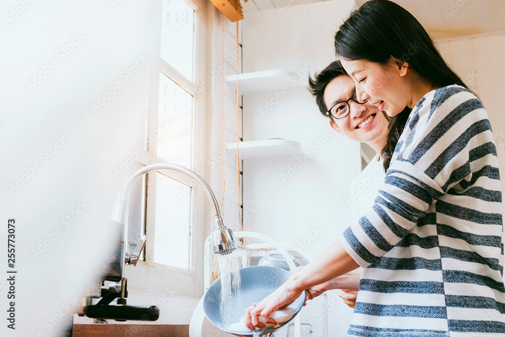 迷人的夫妻亚洲家庭一起洗碗，带着微笑和幸福