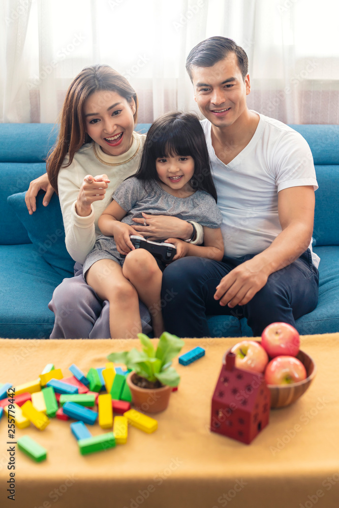 幸福的家庭混血妈妈爸爸和女儿喜欢周末一起看电视节目或玩游戏