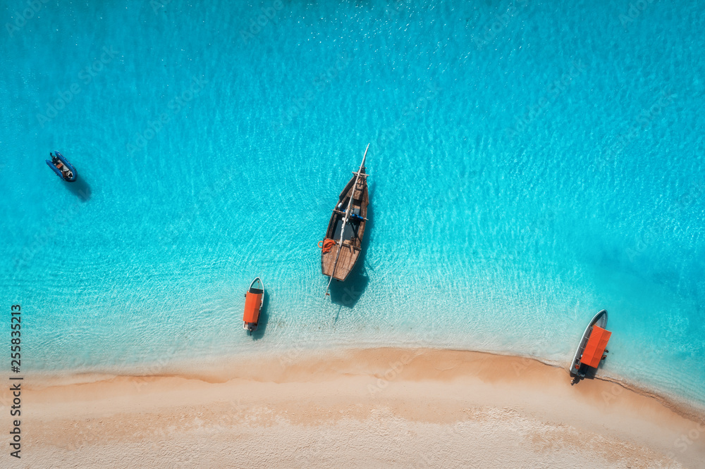 夏日阳光明媚时，渔船在清澈的蓝色水中的鸟瞰图。无人机俯视图