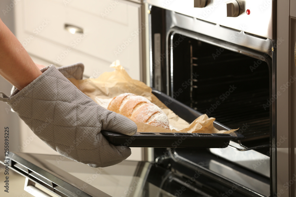 从烤箱取出装有自制面包的烤盘