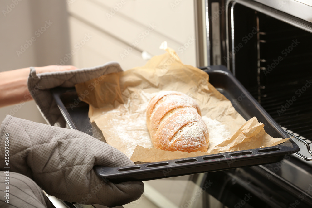 从烤箱取出装有自制面包的烤盘