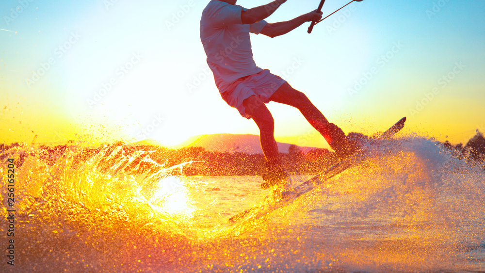 SUN FLARE: Cool surfer dude does 180 ollie while wakeboarding on sunny evening
