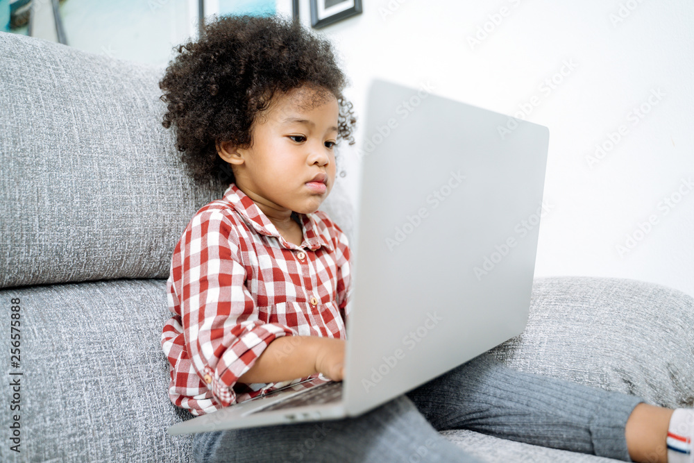 little girl with laptop .afircan kid using laptop