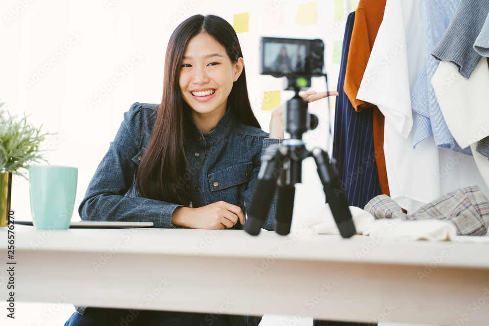 一位年轻的亚洲女性为一位女性时尚博主录制视频。