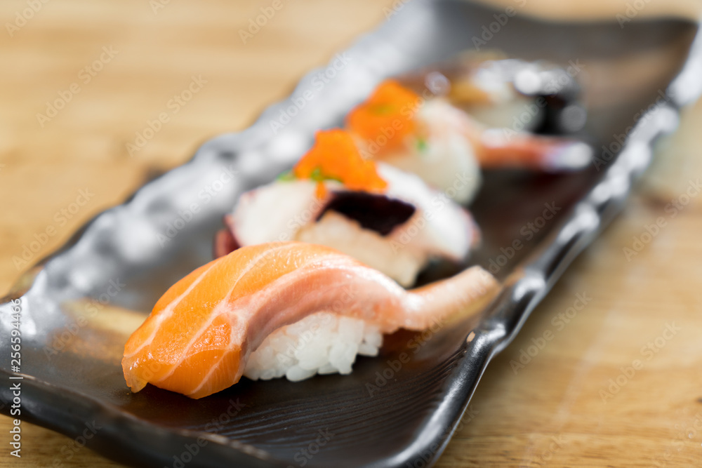 黑盘子里的日本生三文鱼寿司和新鲜混合寿司套装-日式食品套装风格