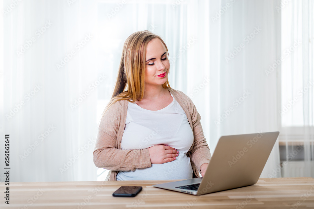 孕妇在家使用笔记本电脑工作，自由职业概念