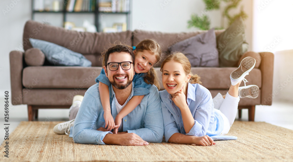 幸福的家庭母亲父亲和孩子女儿在家的沙发上。