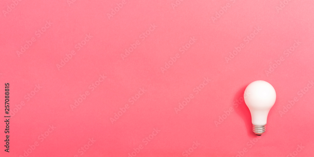 粉红色纸背景上的彩色灯泡