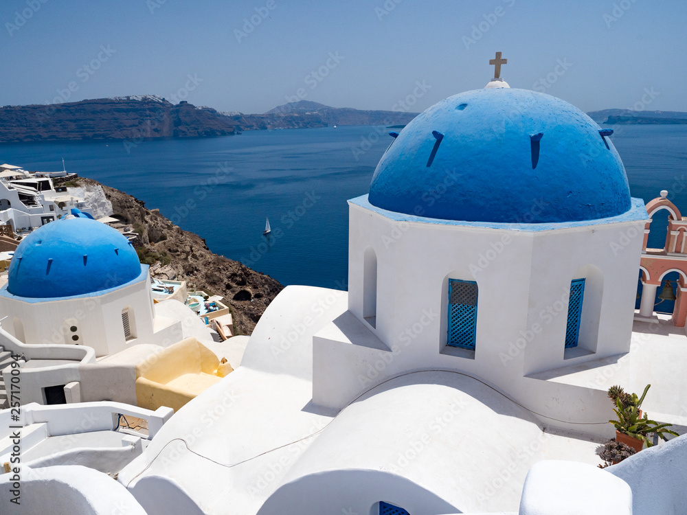 Greece, July, 2018: Oia town on Santorini island. Traditional and famous houses and churches with bl