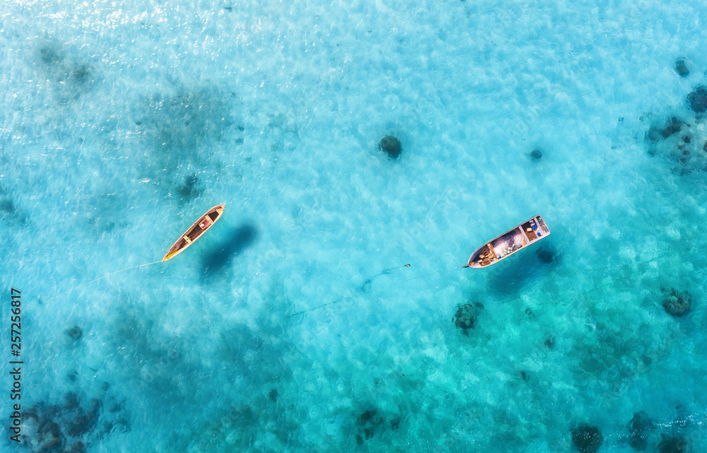 夏季阳光明媚的日子，渔船在清澈的蓝色水中的鸟瞰图。无人机俯视图
