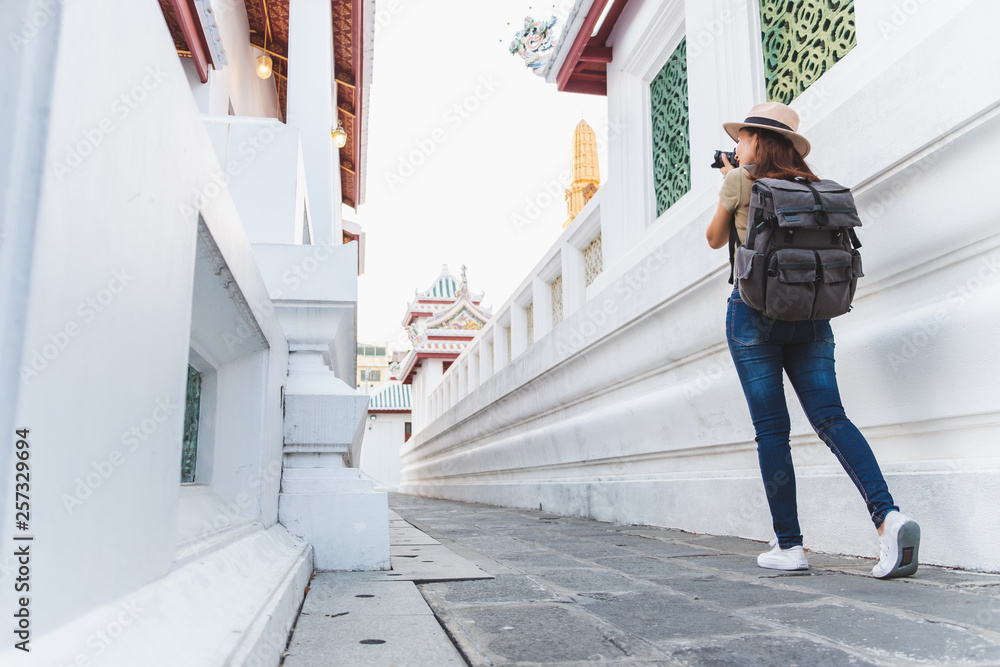 亚洲女子夏季在泰国曼谷美丽的寺庙里旅行，拍照留念