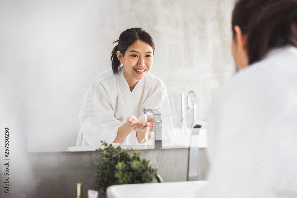 亚洲女性在镜子前清洁面部，护肤和美容概念