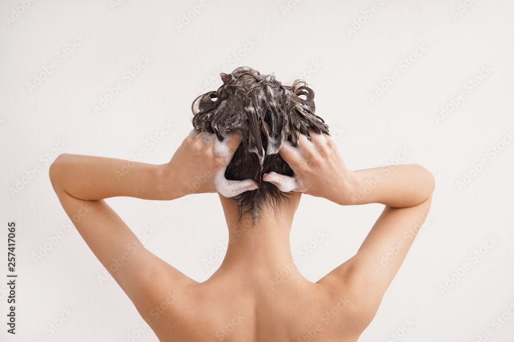 年轻女子在白底上洗头