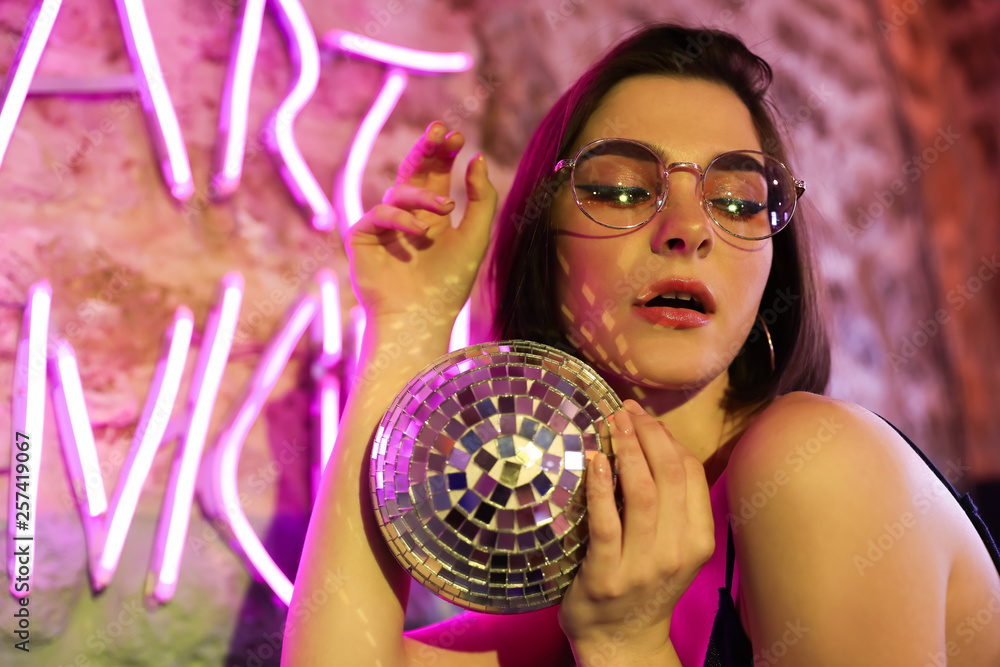 Portrait of beautiful young woman with disco ball