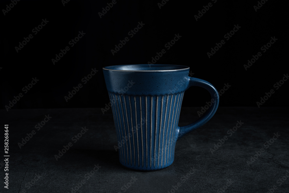 黑色背景的蓝色陶瓷杯