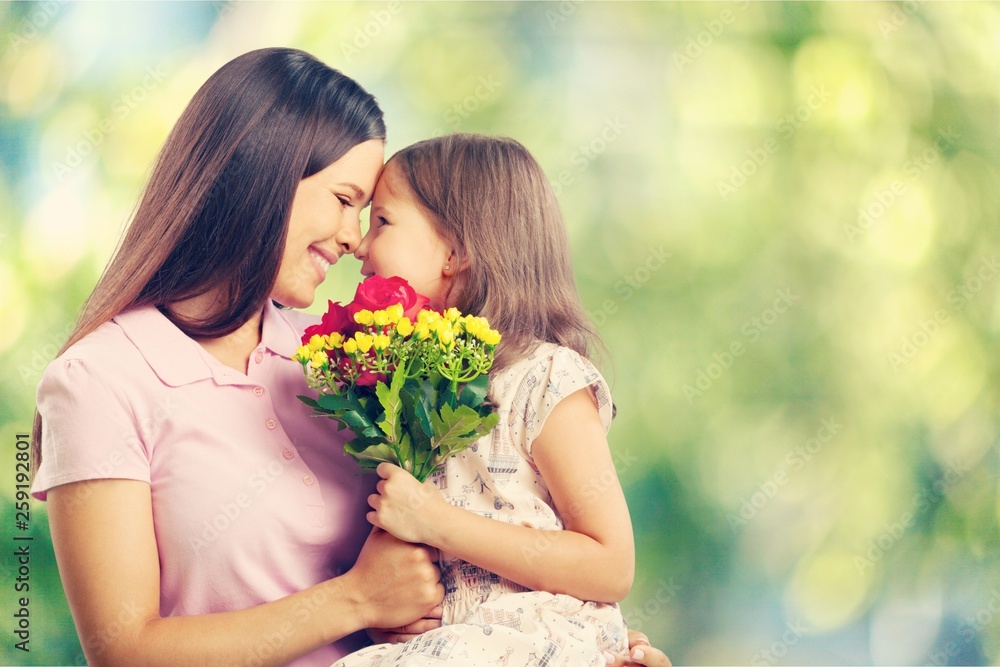 Portrait of happy mother and daughter holding  flowers