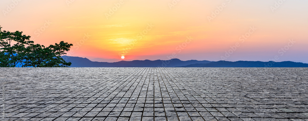 空旷的方形砖地面，日落时美丽的山地自然景观