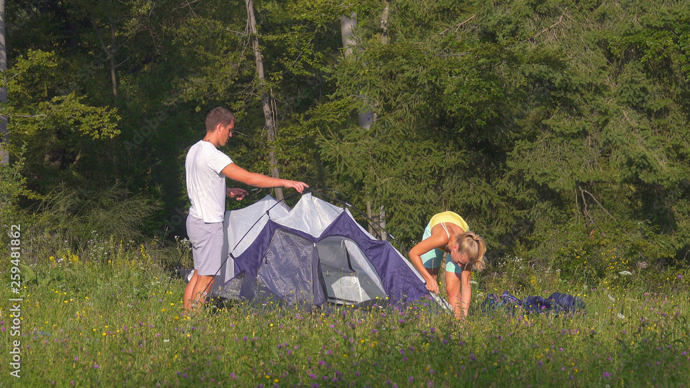一对旅游情侣在一个活跃的暑假里一起搭帐篷。