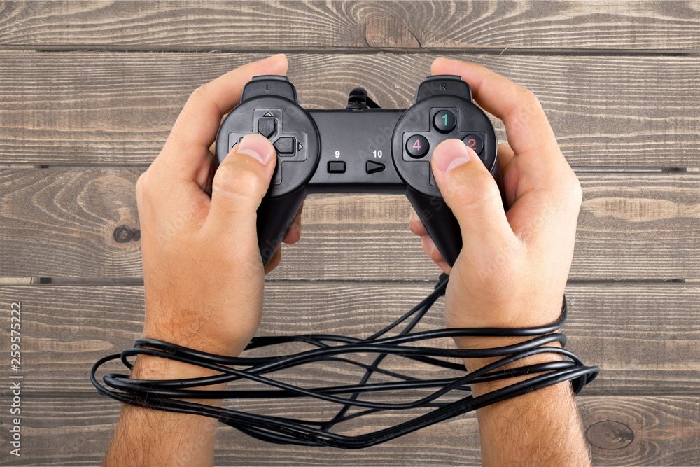 带游戏手柄的有线手意味着视频游戏成瘾