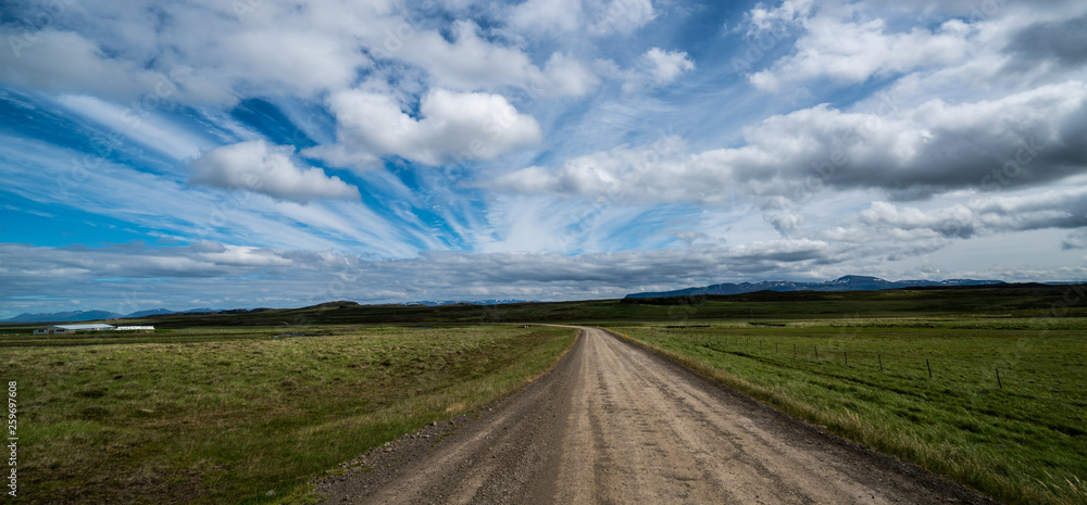 Empty gravel dirt road through countryside landscape and grass field. Nature off road travel trip fo