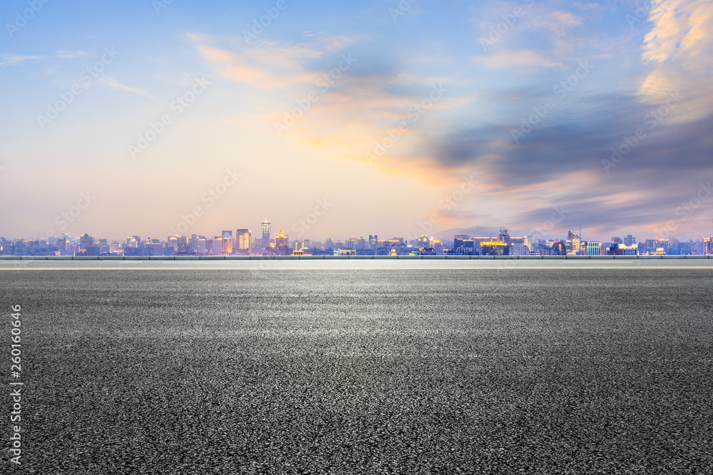 Empty asphalt road and city skyline in hangzhou at sunset