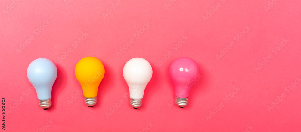 Colored light bulbs on a pink paper background
