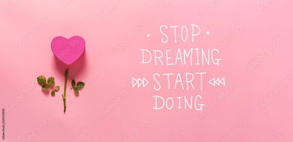 Stop dreaming start doing message with heart flower top view flat lay