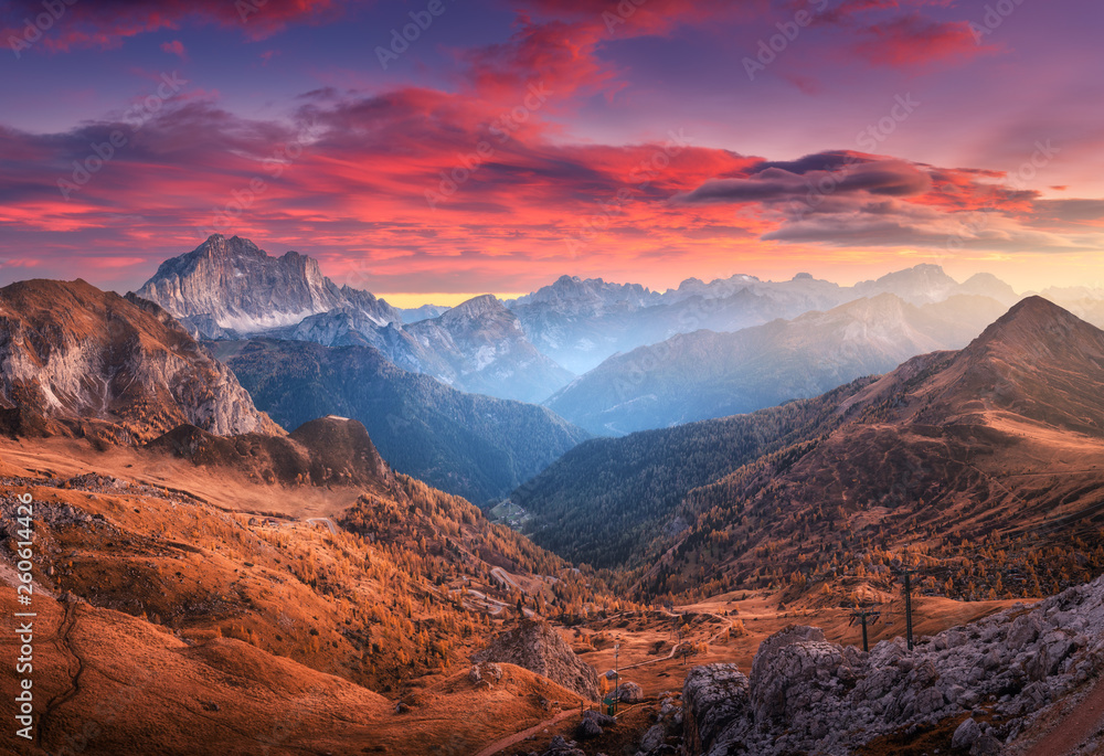 秋天日落时，美丽的山脉上有五颜六色的红色天空和云朵。意大利多洛米蒂