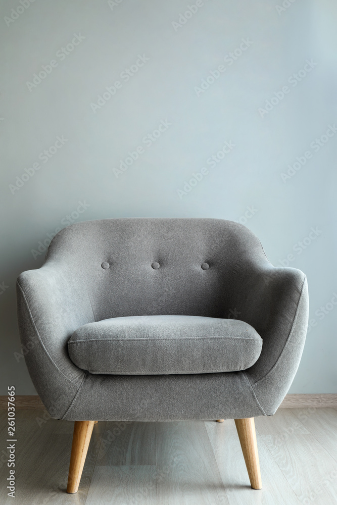 Comfortable armchair near light wall