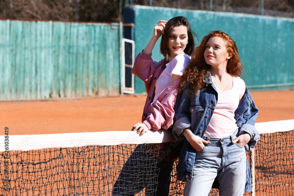 户外网球场上的时尚年轻女性