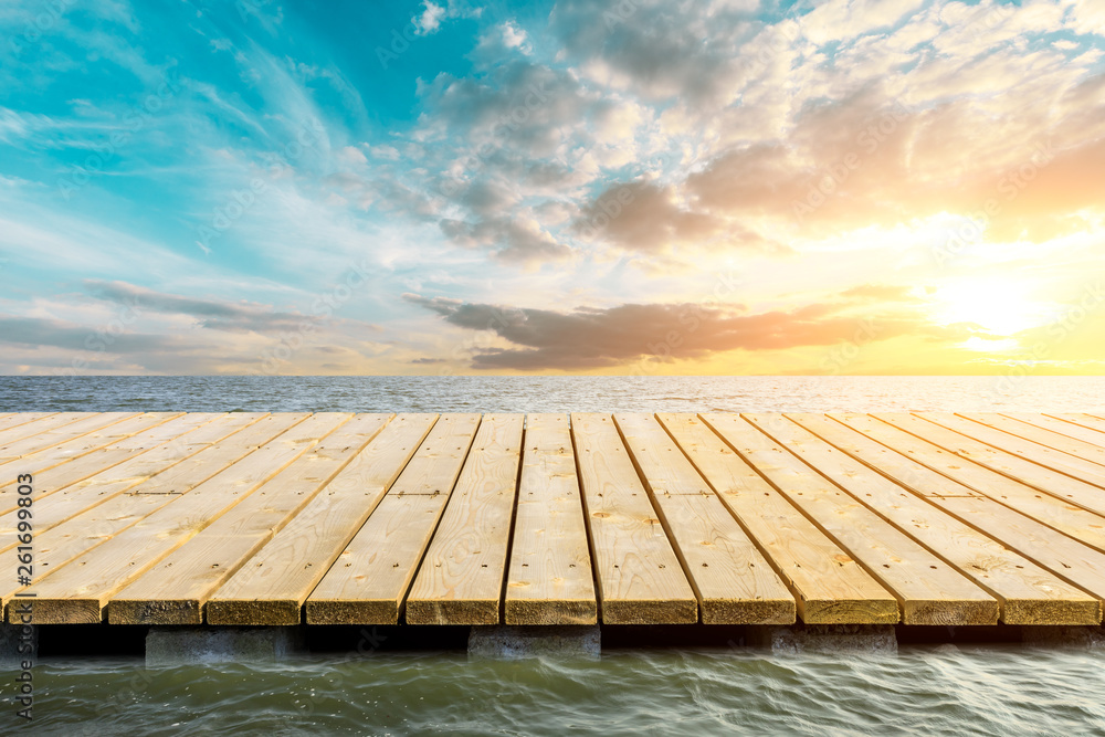 Wooden floor platform and blue sea with sky background