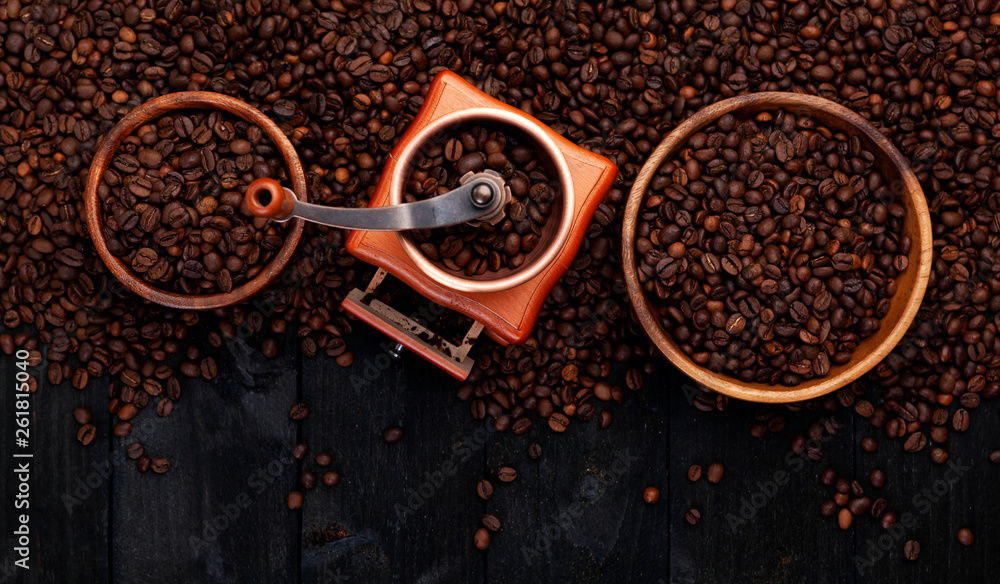 研磨咖啡，咖啡磨，黑色木质背景上的一碗烤咖啡豆，俯视图