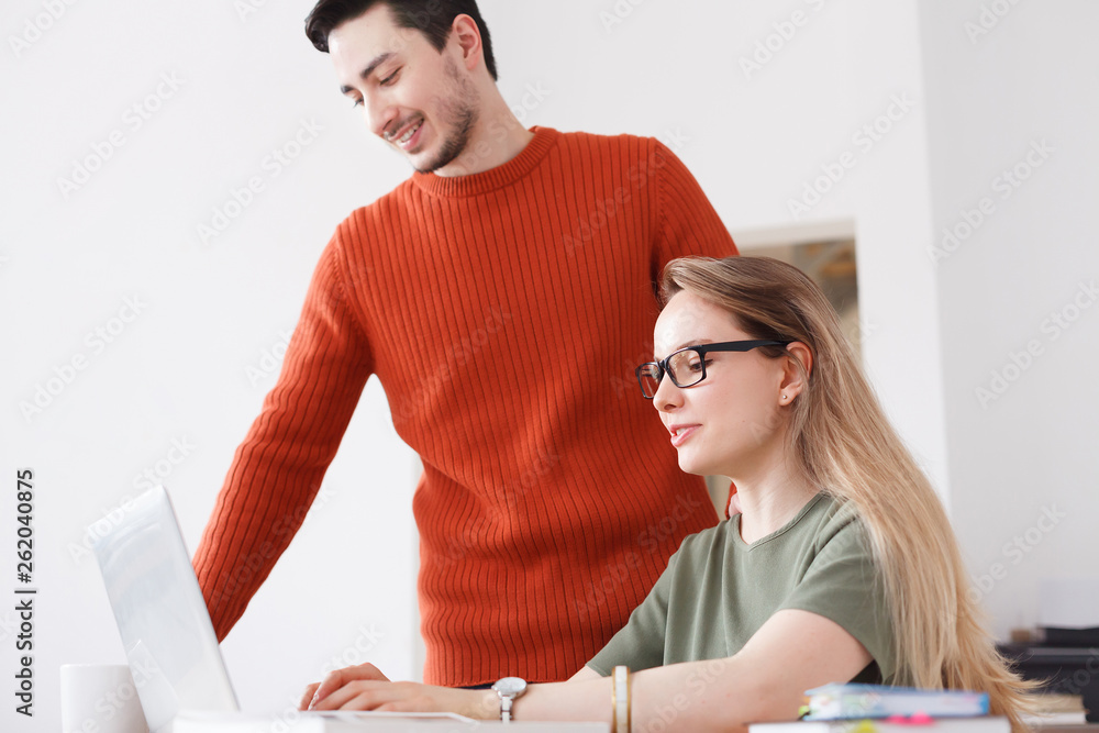 Happy smiling young successful woman manager discusses with client order moments, her colleague stan