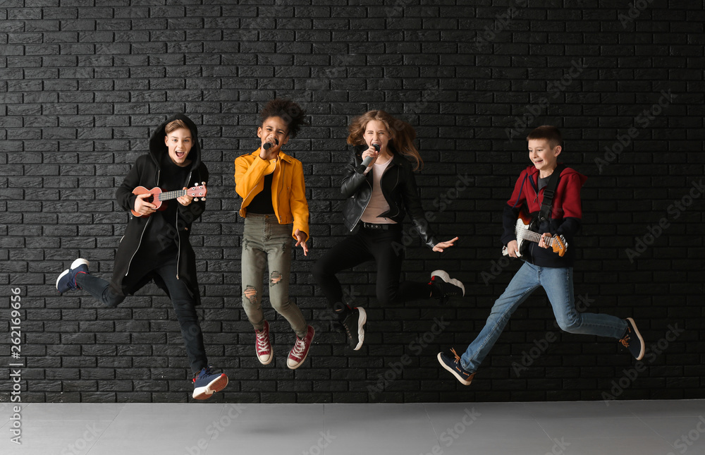 青少年音乐家的跳跃乐队对抗黑暗的墙壁