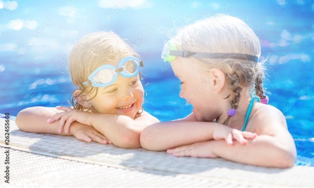 孩子们在泳池里玩耍。两个小女孩在泳池里玩得很开心。暑假和假期结束