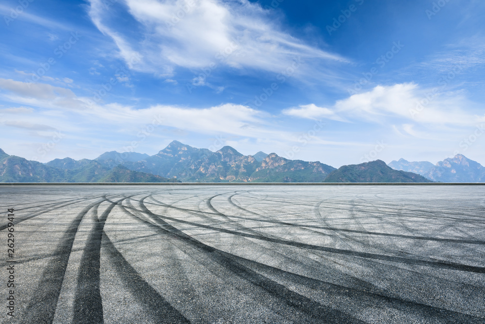 Asphalt race track ground and mountain with clouds background