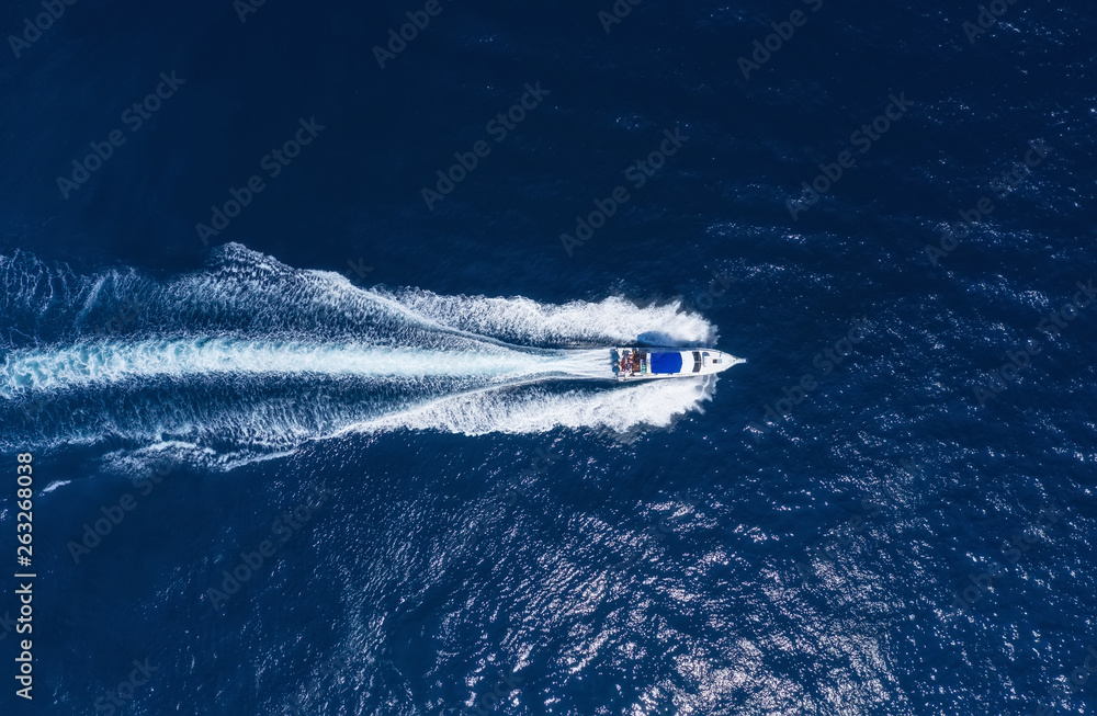 Yachts at the sea in Bali, Indonesia. Aerial view of luxury floating boat on transparent turquoise w