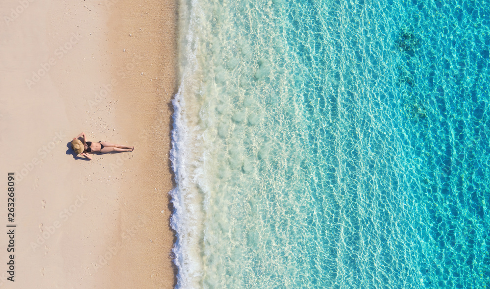 印度尼西亚巴厘岛海滩上一个女孩的鸟瞰图。度假和冒险。海滩和绿松石w