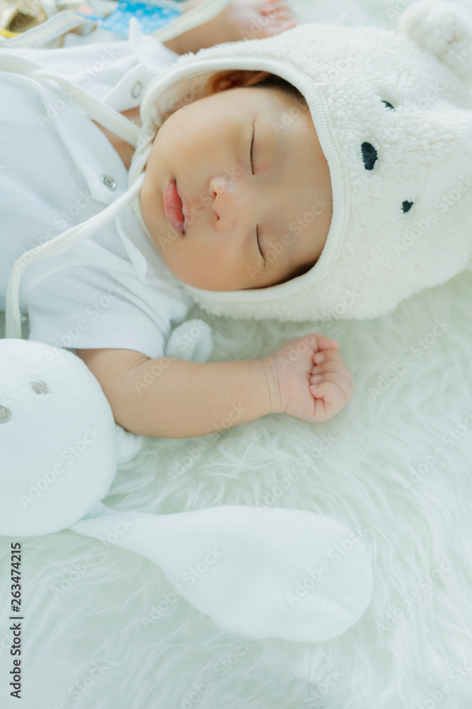 可爱的男婴睡在甜蜜的梦里，睡在平静的白色柔软的床上