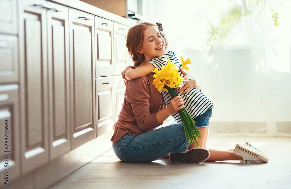 happy mothers day! child daughter   gives mother a bouquet of flowers to narcissus and gift.