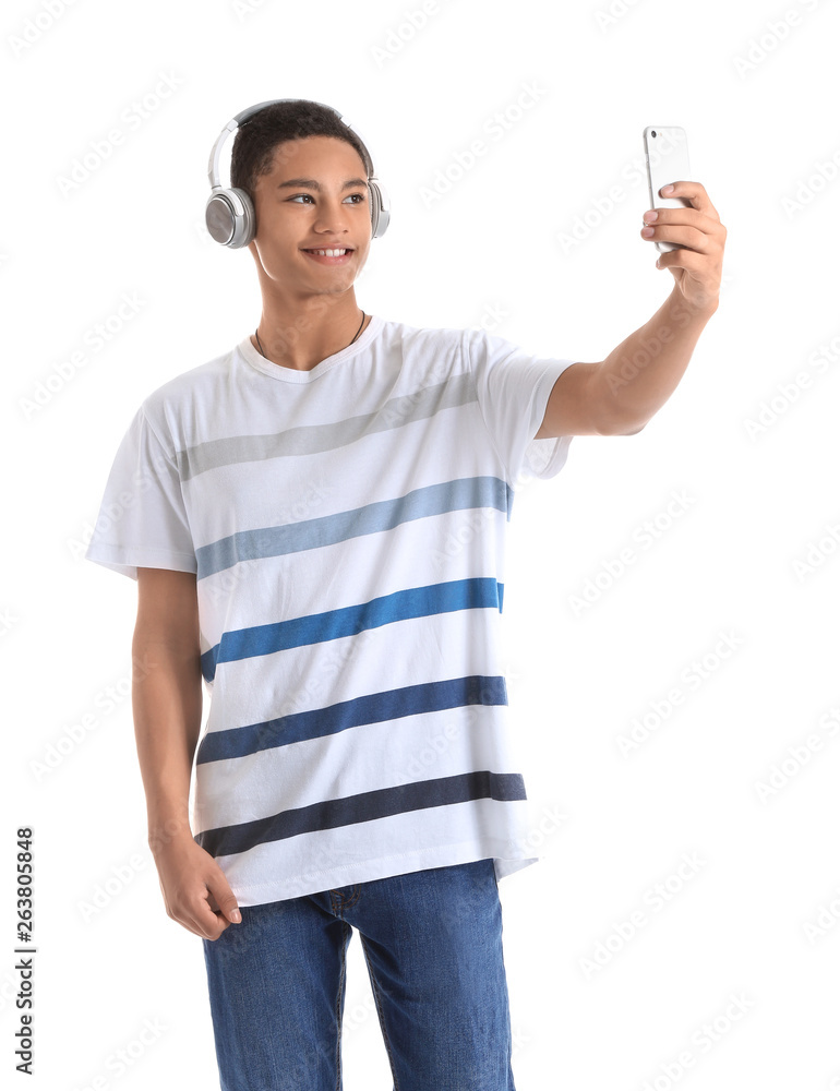 白人背景下戴着耳机和手机的非裔美国少年肖像